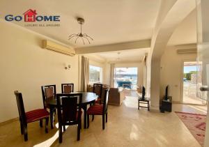 a dining room and living room with a table and chairs at Stylish 4 BR with a Private Heated Pool V15 at White Villas in Hurghada