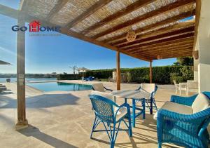 a patio with a table and chairs and a pool at Stylish 4 BR with a Private Heated Pool V15 at White Villas in Hurghada +20 photos