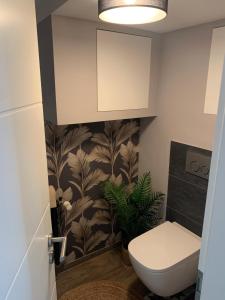 a bathroom with a toilet and a plant on the wall at Apartment Hearzzeit in Herzberg am Harz +18 photos