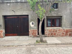 a building with a door and a tree in front of it at Dulce Claudina 2 in Mercedes