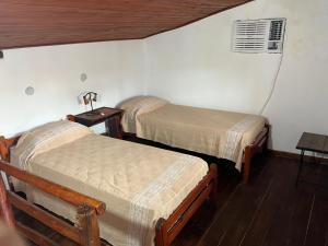 a room with two beds and a table with a fan at Dulce Claudina 2 in Mercedes