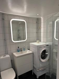 une salle de bain avec une machine à laver et un lave-linge dans l'établissement CHARLISE APARTMENTs, à Oslo