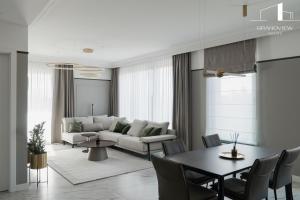 a living room with a couch and a table at Brabank Penthouse Old Town View, Sauna & Parking by Grandviewestate in Gdańsk