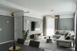a living room with a couch and a table at Brabank Penthouse Old Town View, Sauna & Parking by Grandviewestate in Gdańsk
