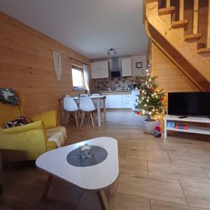 a living room with a christmas tree and a kitchen at Domki u Basi in Kluszkowce