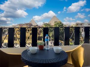 une table sur un balcon avec vue sur les pyramides dans l'établissement Pyramids Art View Inn, au Caire