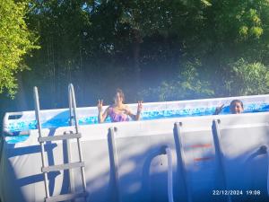 two people are in a swimming pool at Hostal Fernanda in Santa Cruz