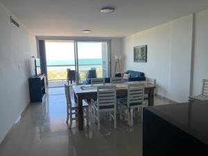 ein Esszimmer mit Tisch und Stühlen und dem Meer in der Unterkunft Amplio con vista al mar in Balneario Monte Hermosa