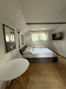 a small bedroom with a bed and a table at Pokoje Gościnne Mirena in Karpacz +7 photos