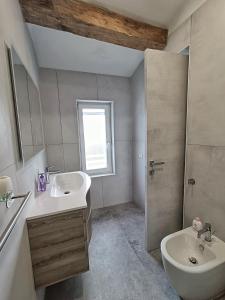 ein Badezimmer mit Waschbecken, Toilette und Dusche in der Unterkunft Casa LaSer in Cotignola