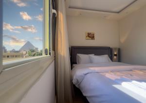 a bedroom with a bed and a window with a view at Pyramids Art Inn in Cairo