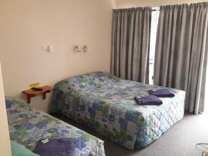 1 dormitorio con 2 camas y ventana en Ocean View Motel Bowen, en Bowen