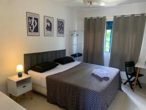 a bedroom with a bed with a black and white comforter at Pousada Casa da Penha in Abraão