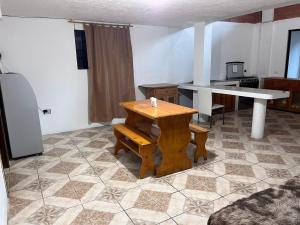 a table and bench in a room with a kitchen at Residencia Las Colinas in Juivi +1 photo