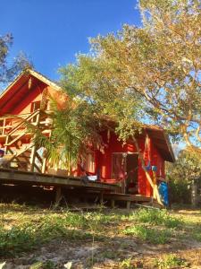 una casa roja sentada en un montón de madera en Condomínio 3 casas, en Florianópolis 28 fotos más