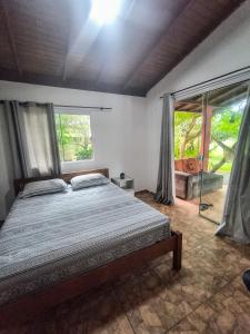 Un dormitorio con una cama y una ventana grande en Condomínio 3 casas, en Florianópolis