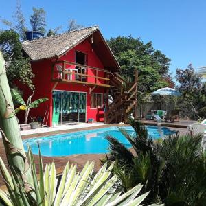 una casa con piscina y un edificio rojo en Condomínio 3 casas, en Florianópolis