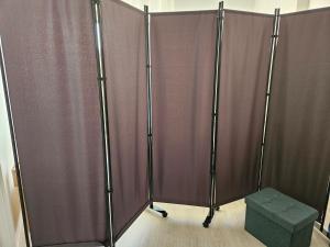 a pair of curtains in a room with a green stool at Lit simple -canapé lit dans appt partagé in Noisy-le-Grand