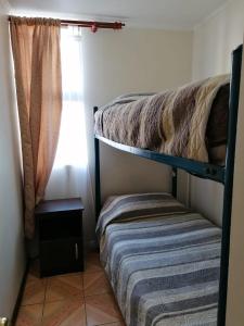 a bedroom with two bunk beds and a window at D14-9 Arriendo diario a pasos de la playa Arica in Arica