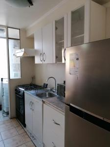 a kitchen with a stainless steel refrigerator and a sink at D12-E15 Amoblado y equipado a pasos de la playa Arica in Arica