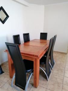 a wooden table with black chairs around it at D12-E15 Amoblado y equipado a pasos de la playa Arica in Arica +2 photos
