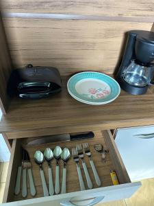 a drawer in a kitchen with a plate and utensils at Apto Natureza Verde Manauara II in Manaus