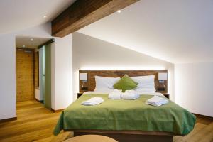 a bedroom with a bed with two towels on it at Hotel & Restaurant Zum Schwarzen Bären in Andermatt