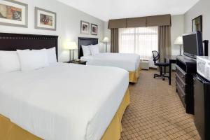 a hotel room with two beds and a desk at CASH REWARDS INN & SUITEs in Roswell