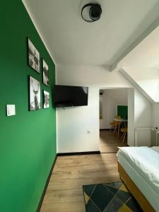 a bedroom with a green accent wall and a bed at Pokoje Gościnne Mirena in Karpacz