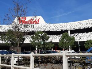 a restaurant with cars parked in front of a building at Panorama Deluxe in Rosny-sous-Bois
