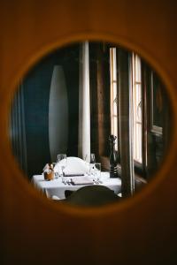 a room with a table with a mirror and windows at Hotel & Restaurant Zum Schwarzen Bären in Andermatt