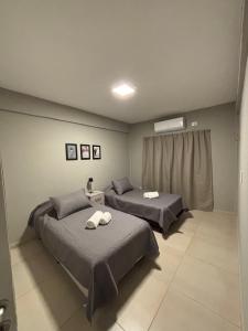 una camera da letto con due letti con asciugamani sopra di Departamentos corrientes a Corrientes