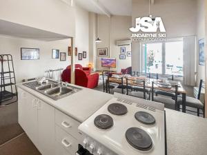 a kitchen with a stove and a dining room at Razorback 2 in Jindabyne