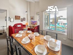 a dining room with a table with plates and glasses at Razorback 2 in Jindabyne