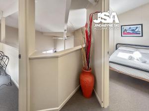 a small room with a red vase next to a bed at Razorback 2 in Jindabyne