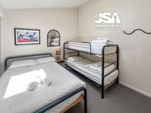 a room with two bunk beds and a mirror at Razorback 2 in Jindabyne
