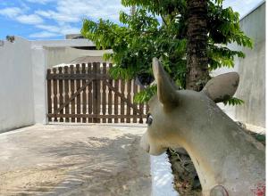 a statue of a donkey next to a tree at Hostel 5C - Itanhaém in Itanhaém