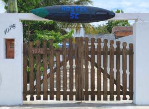 a wooden fence with a surfboard on top of it at Hostel 5C - Itanhaém in Itanhaém