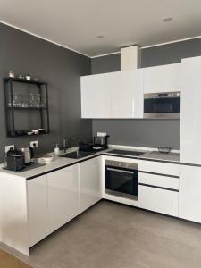 a white kitchen with white cabinets and appliances at NONSOLOMARE Wifi aria condizionata ascensore in Sanremo