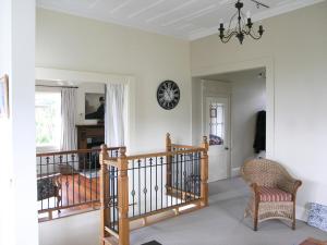 a room with a staircase and a clock on the wall at Blue Seas Villa in Napier