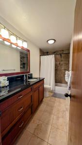 een badkamer met een wastafel, een toilet en een spiegel bij Seaside Retreat Condo in Kailua-Kona +32 foto's