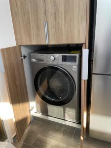 a stainless steel washer and dryer in a cabinet at Roof en Manzanillo a 5 min de playa in Manzanillo