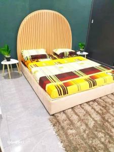 a large bed with a wooden headboard in a bedroom at Résidence Ahydeney in Abidjan