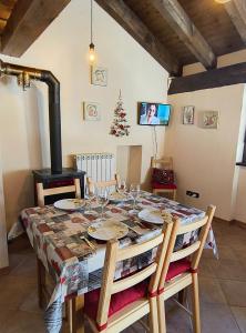 a dining room with a table and a wood stove at Petit Royal - Maisons de Charme - Appartamento per 6 persone - con Balcone e Soppalco in Champoluc