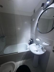 a bathroom with a sink and a tub and a mirror at Carlis Home in Cordoba +3 photos