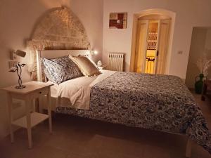a bedroom with a large bed and a table with a lamp at Adalù apartments in Conversano