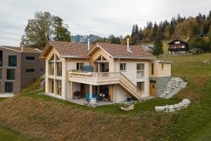 une grande maison au sommet d'une colline dans l'établissement Apartment Strohballenhaus, à Amden