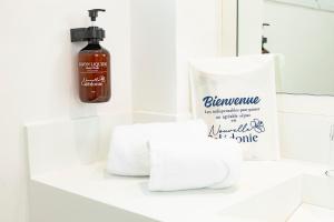 a bathroom sink with a bottle of soap and towels at Hotel Beaurivage in Noumea +37 photos