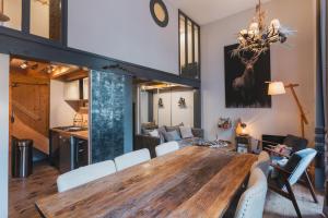 a dining room and living room with a wooden table and chairs at L'Eveil - 65m2 - 6-8P - Centre Ville Cauterets in Cauterets