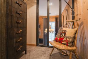 a wooden chair with a pillow on it in a room at L'Eveil - 65m2 - 6-8P - Centre Ville Cauterets in Cauterets